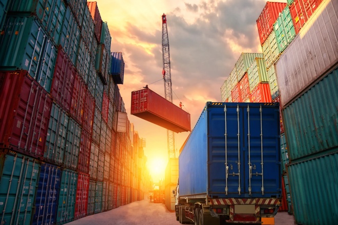 Truck driving through stacks of shipping containers