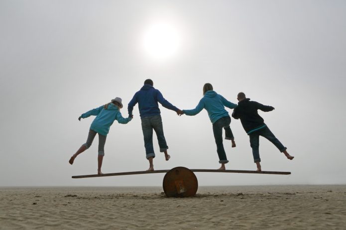 People holding hands while balancing 