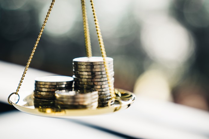 Coin stacked on a balance scale.