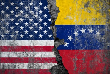 The national flags of USA and Venezuela are painted on a rough, weathered concrete surface.
