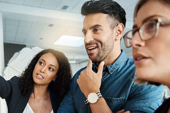 Three people looking at a board