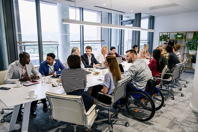 Empleados hablando en torno a una mesa.